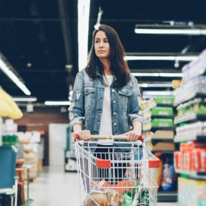 jeune femme au supermarché avec chariot de courses