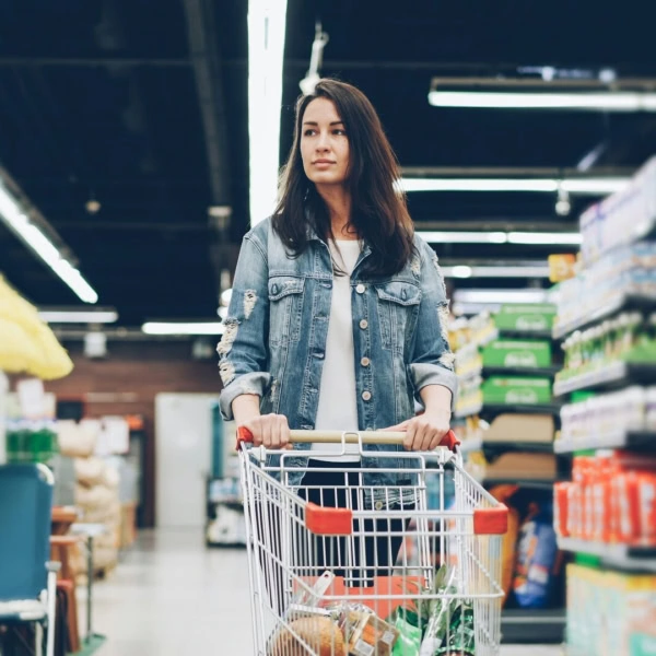 jeune femme au supermarché avec chariot de courses