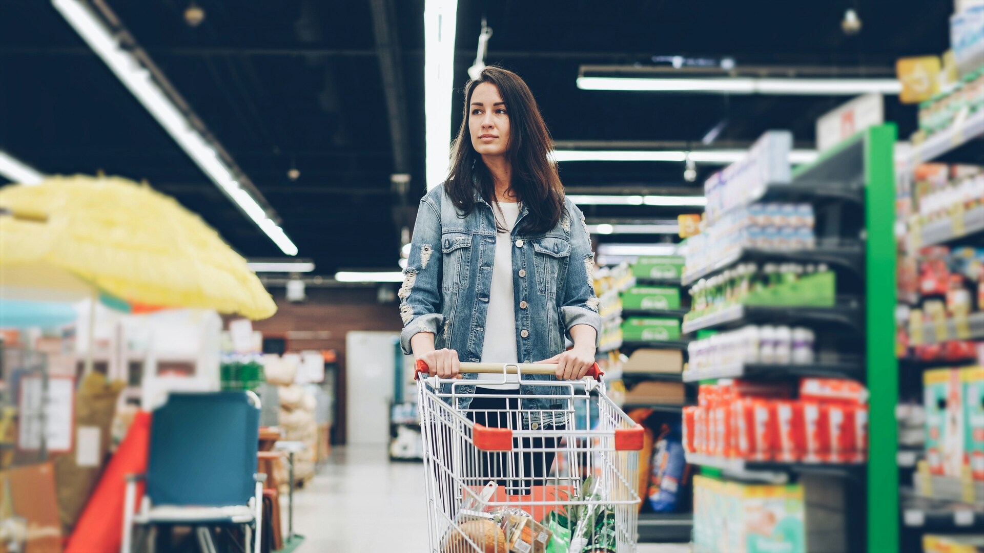 jeune femme au supermarché avec chariot de courses