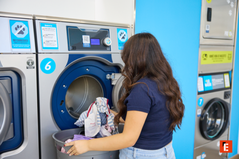jeune femme charge un lave linge en laverie 6
