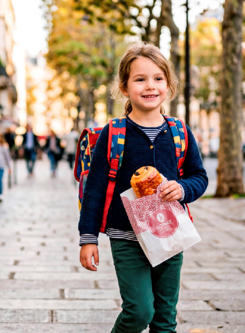 jeune fille souriante avec goûter en ville