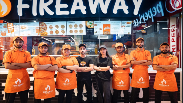 fireaway pizza team poses in orange uniforms