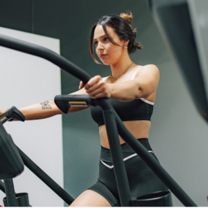 junge frau auf dem crosstrainer im modernen gym