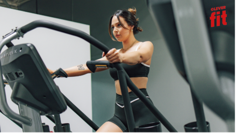 junge frau auf dem crosstrainer im modernen gym