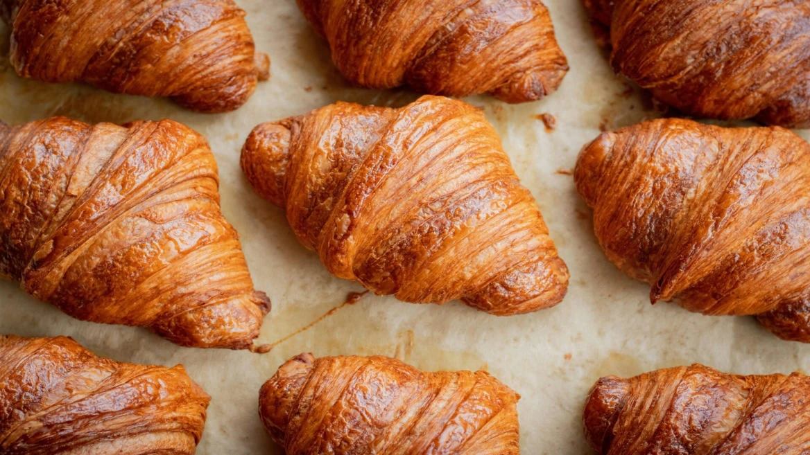 golden brown croissants, freshly baked on parchment
