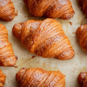 golden brown croissants, freshly baked on parchment