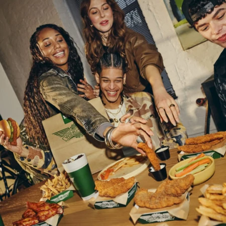 groupe d’amis gourmands autour de fast food Wingstop