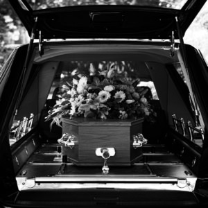 cercueil fleuri dans un corbillard noir
