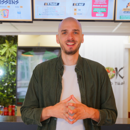 homme souriant dans un restaurant moderne et tropical