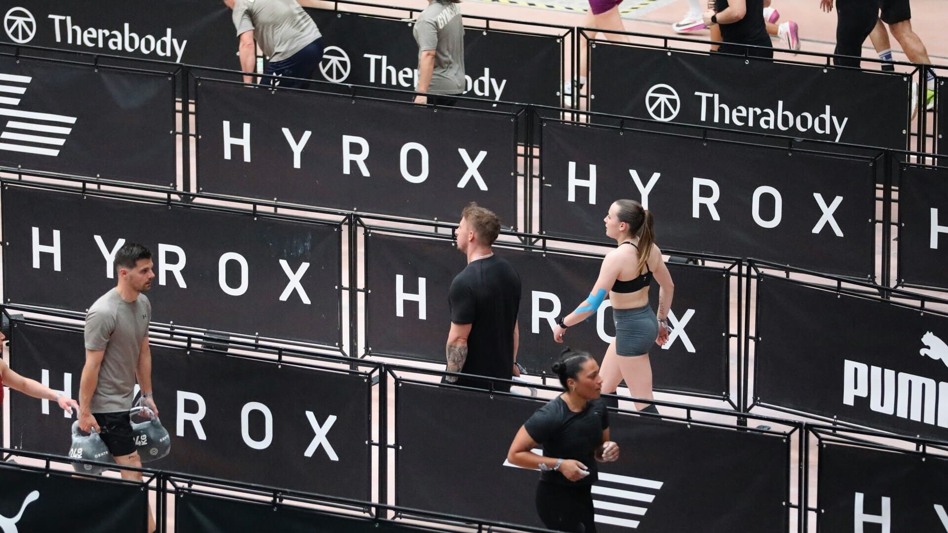 competizione indoor hyrox: atleti e kettlebell in azione