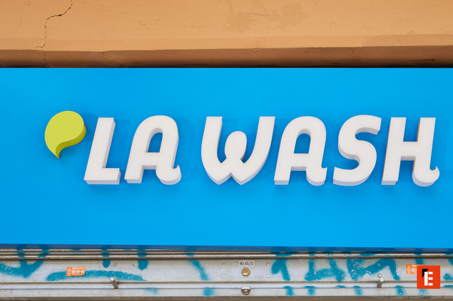 enseigne la wash sur façade bleue urbaine