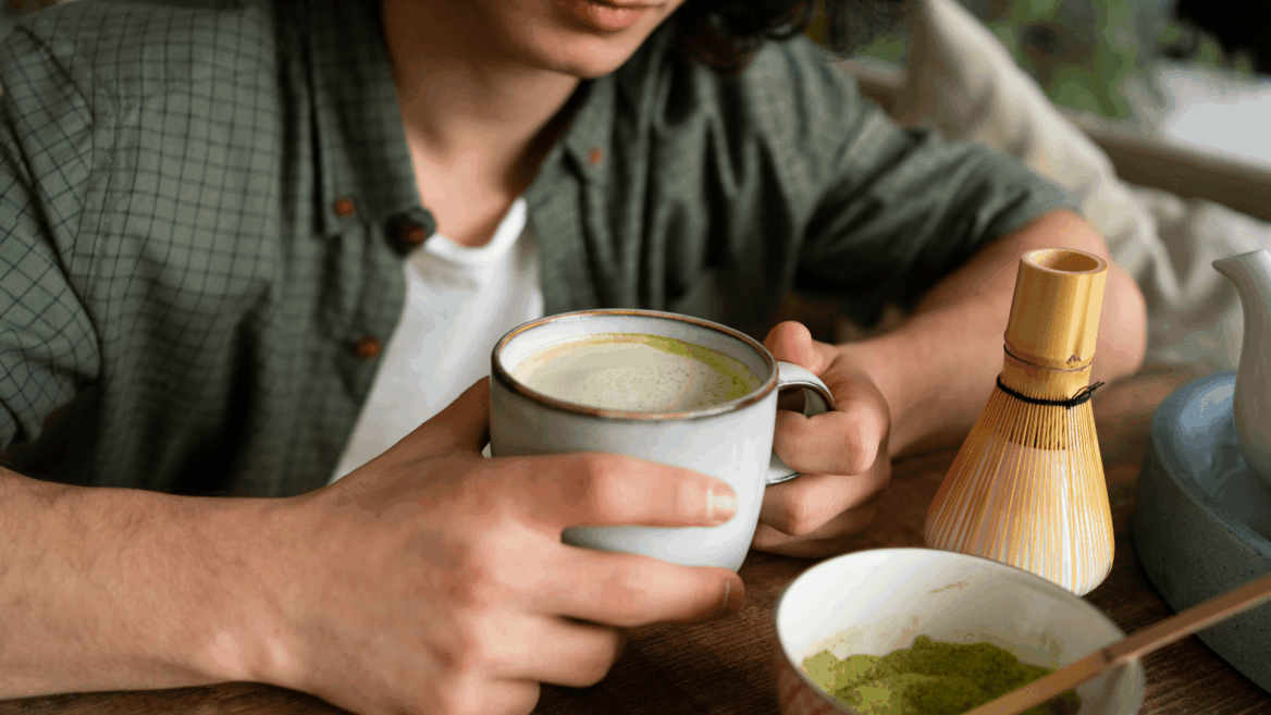 matcha latte en taza y batidor de bambú