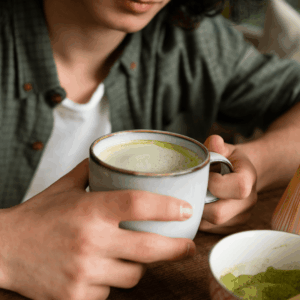 matcha latte en taza y batidor de bambú