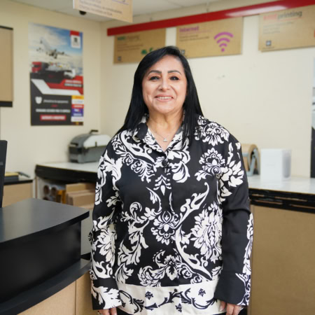 mujer sonriente con blusa floral en oficina