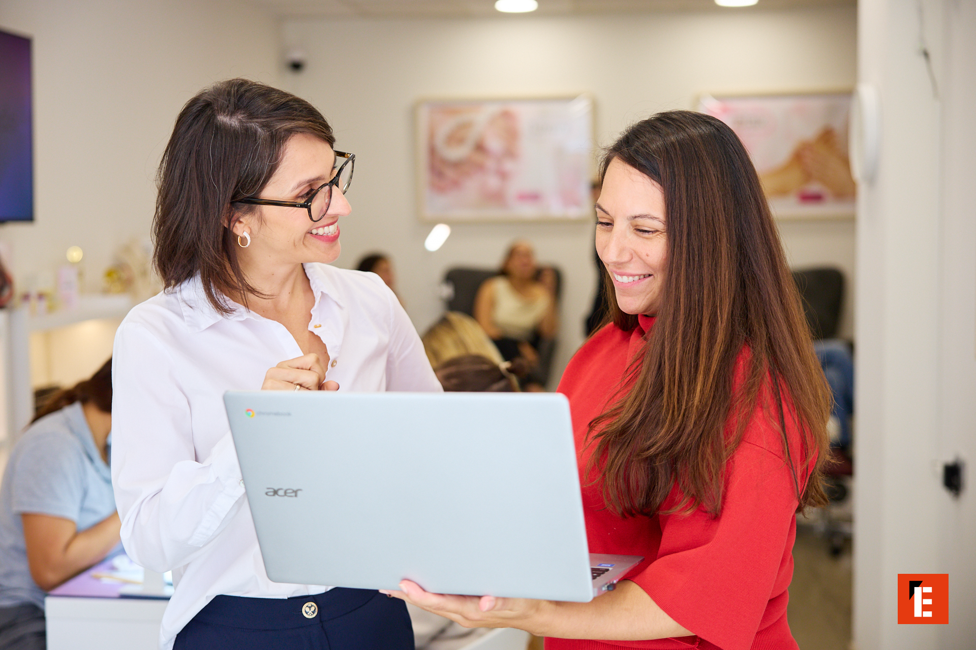 dos mujeres colaboran con portátil acer