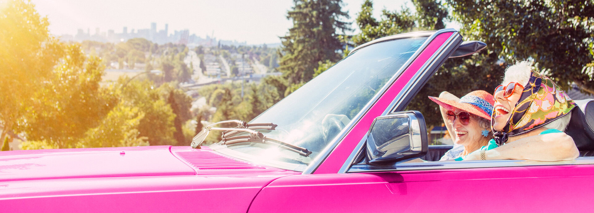 deux femmes souriantes en cabriolet rose en Été
