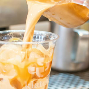 caramel iced coffee being poured into cup