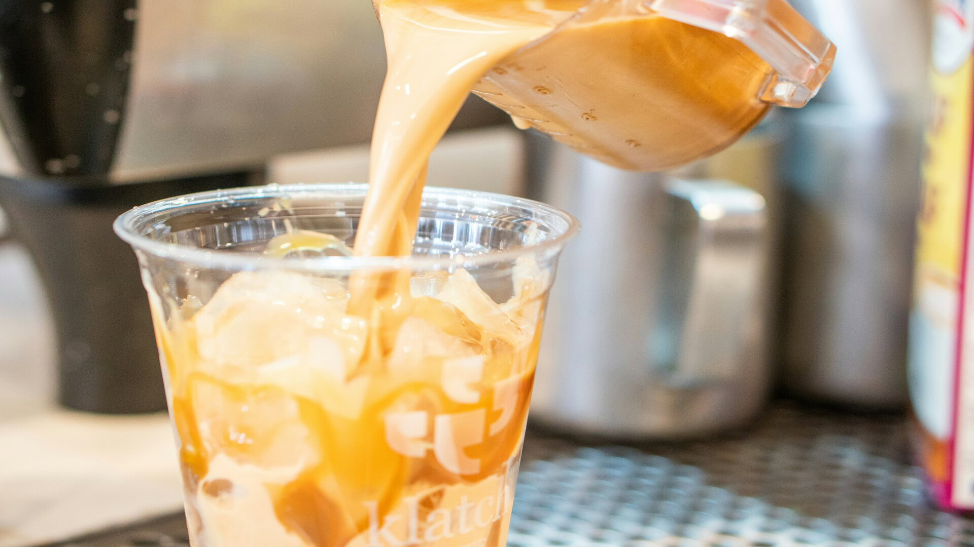 caramel iced coffee being poured into cup