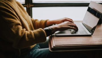 personne tapant sur ordinateur portable au bureau