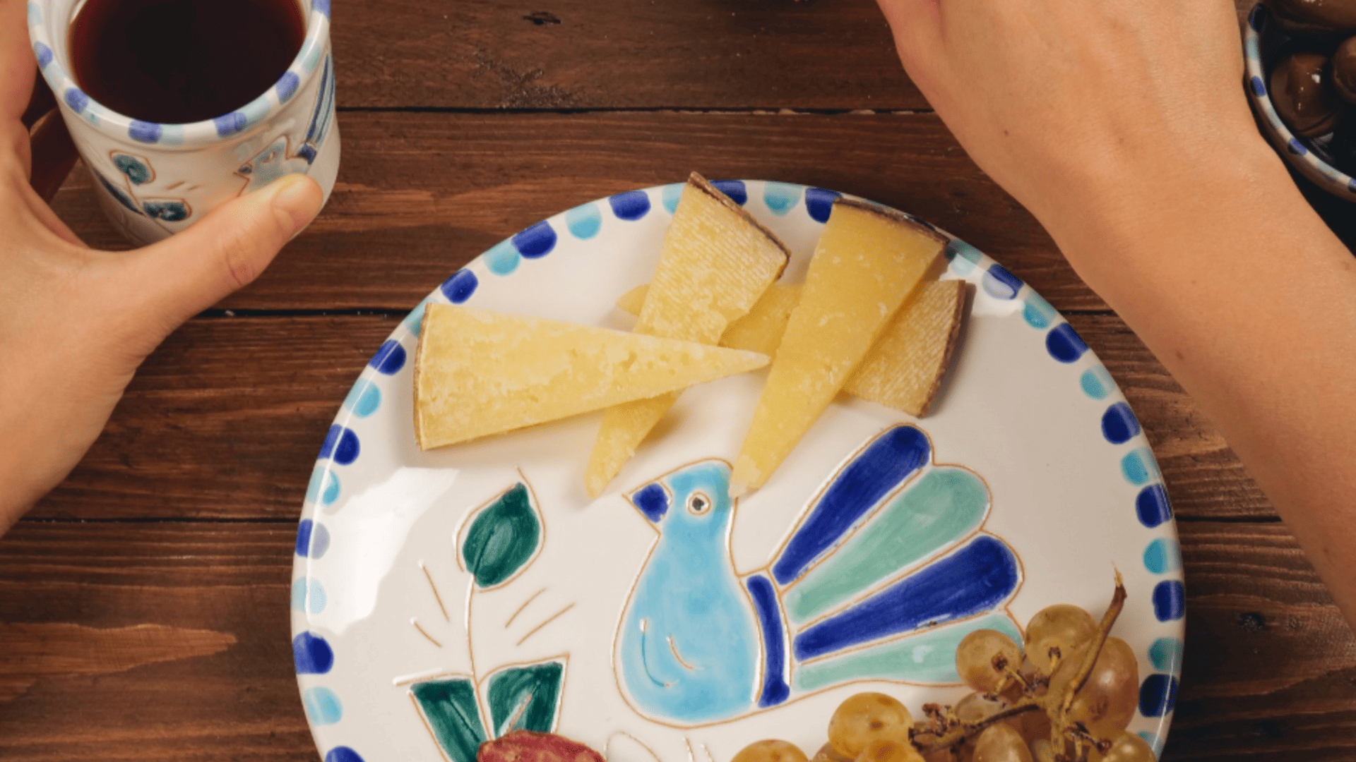 piatto decorato con formaggio, uva e tazza in tavola