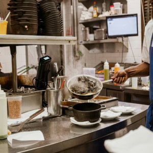 chef preparing steaming mussels in a busy kitchen