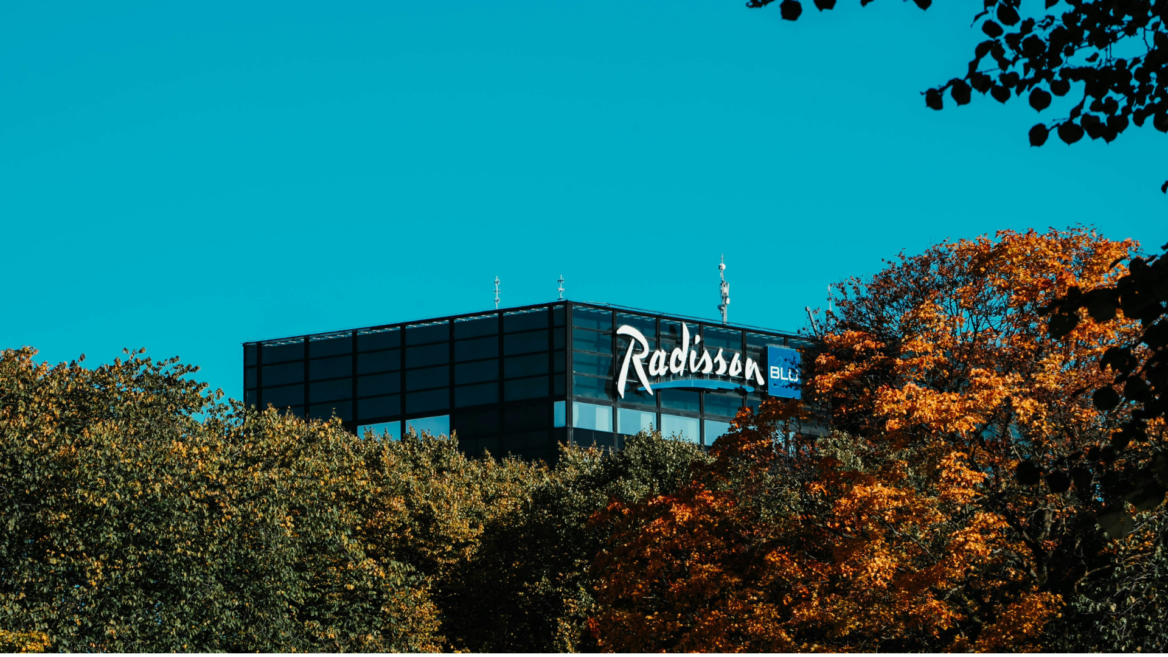 radisson blu hotel über herbstbäumen und blauem himmel