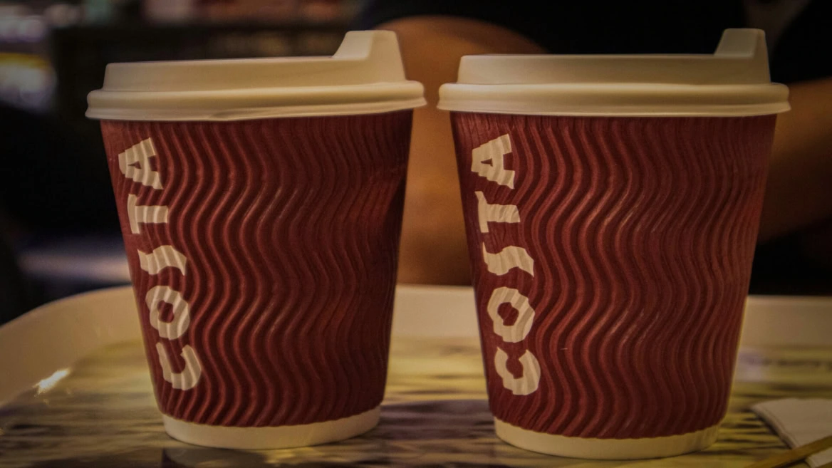 two costa coffee cups on table