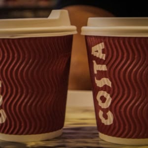two costa coffee cups on table