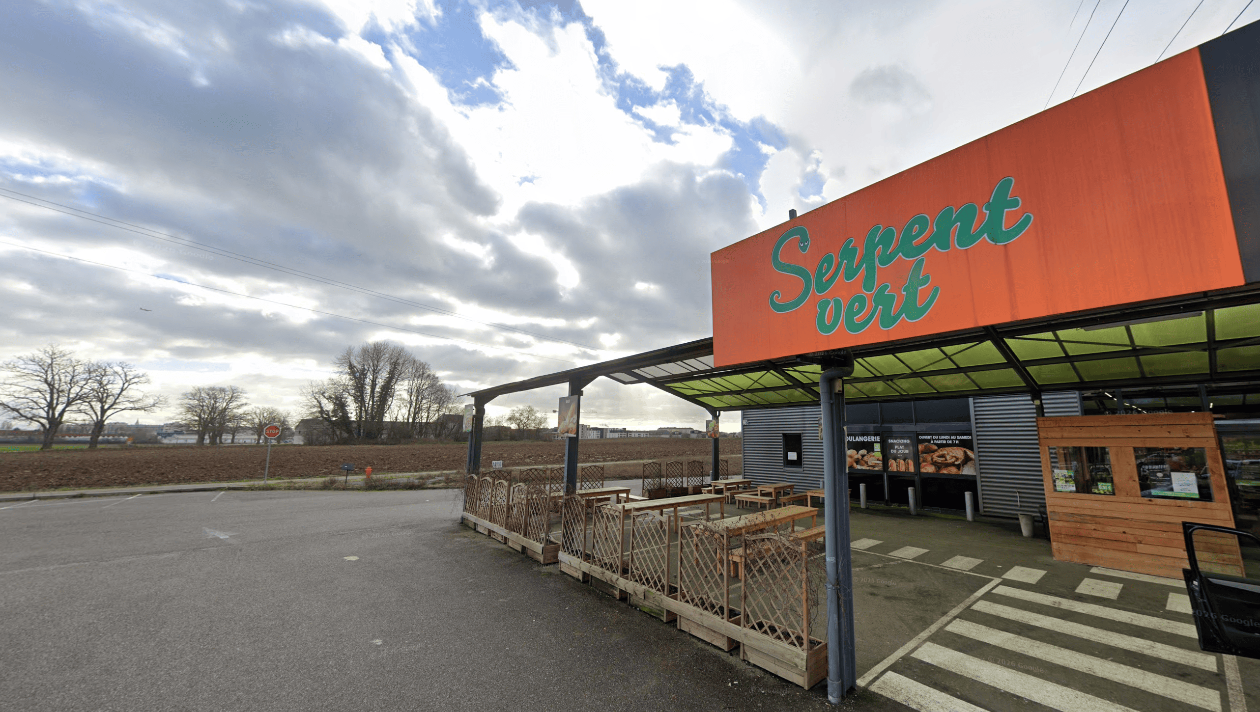 boulangerie serpent vert, façade orange et ciel nuageux