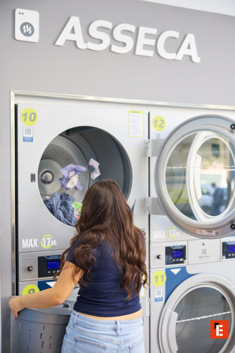 femme charge une machine en laverie moderne