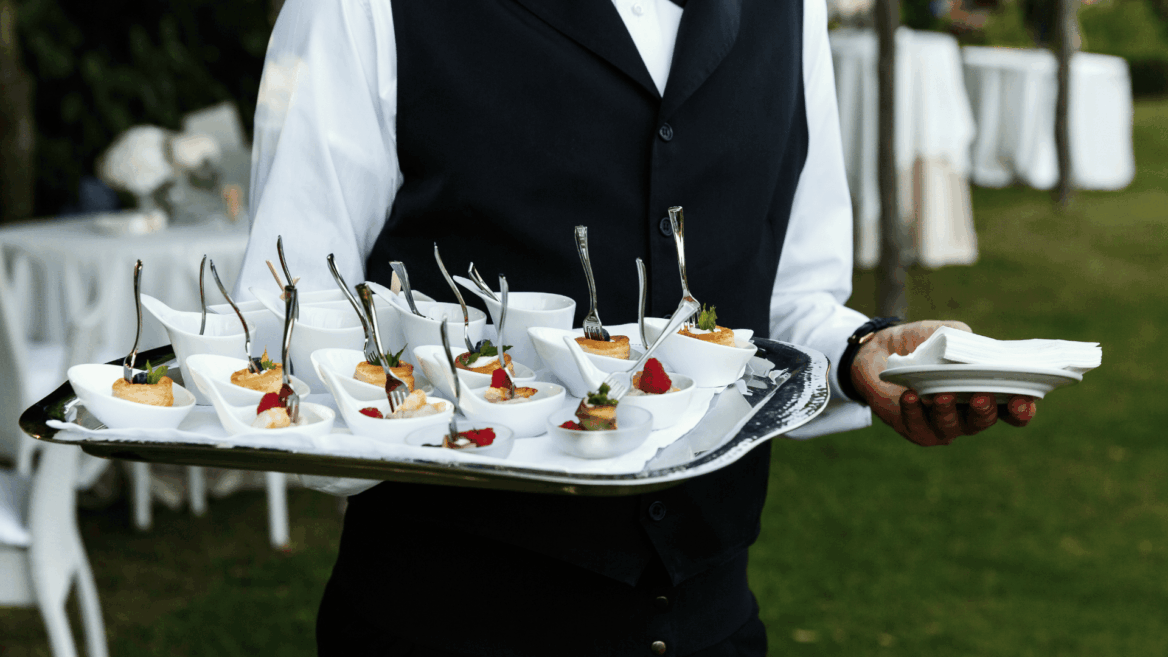 camarero con bandeja de aperitivos en evento exterior