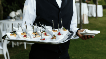 camarero con bandeja de aperitivos en evento exterior