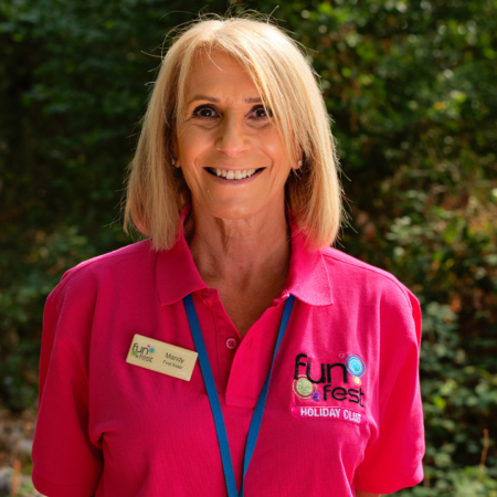 smiling woman in pink polo outdoors