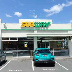 façade d’un subway au soleil, avec stationnement