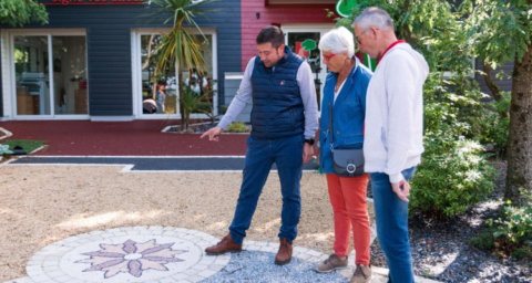 trois personnes observent une mosaïque au sol