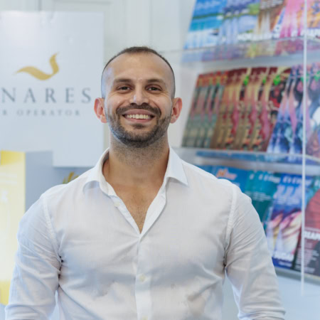 uomo sorridente in ufficio turistico bénarès tour operator