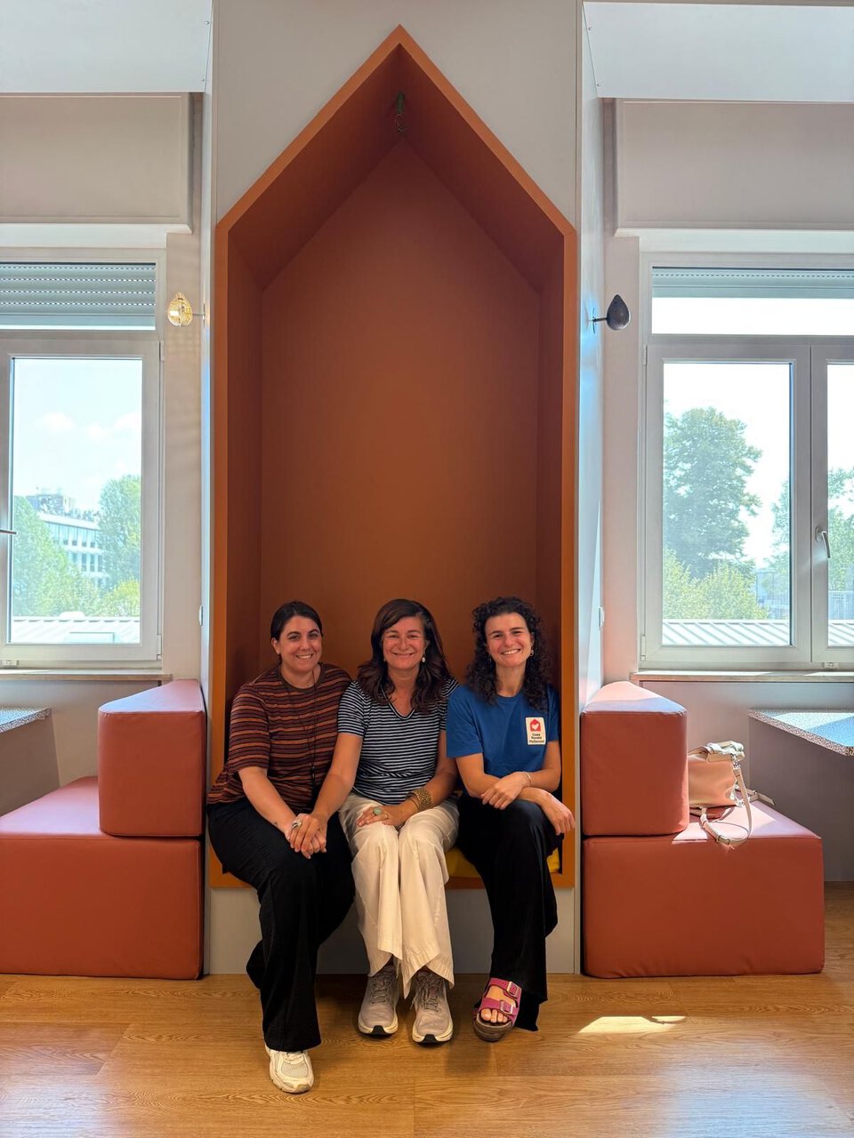 tre donne sorridenti in interno moderno luminoso