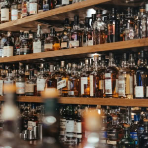 wall of whiskey bottles on wooden shelves