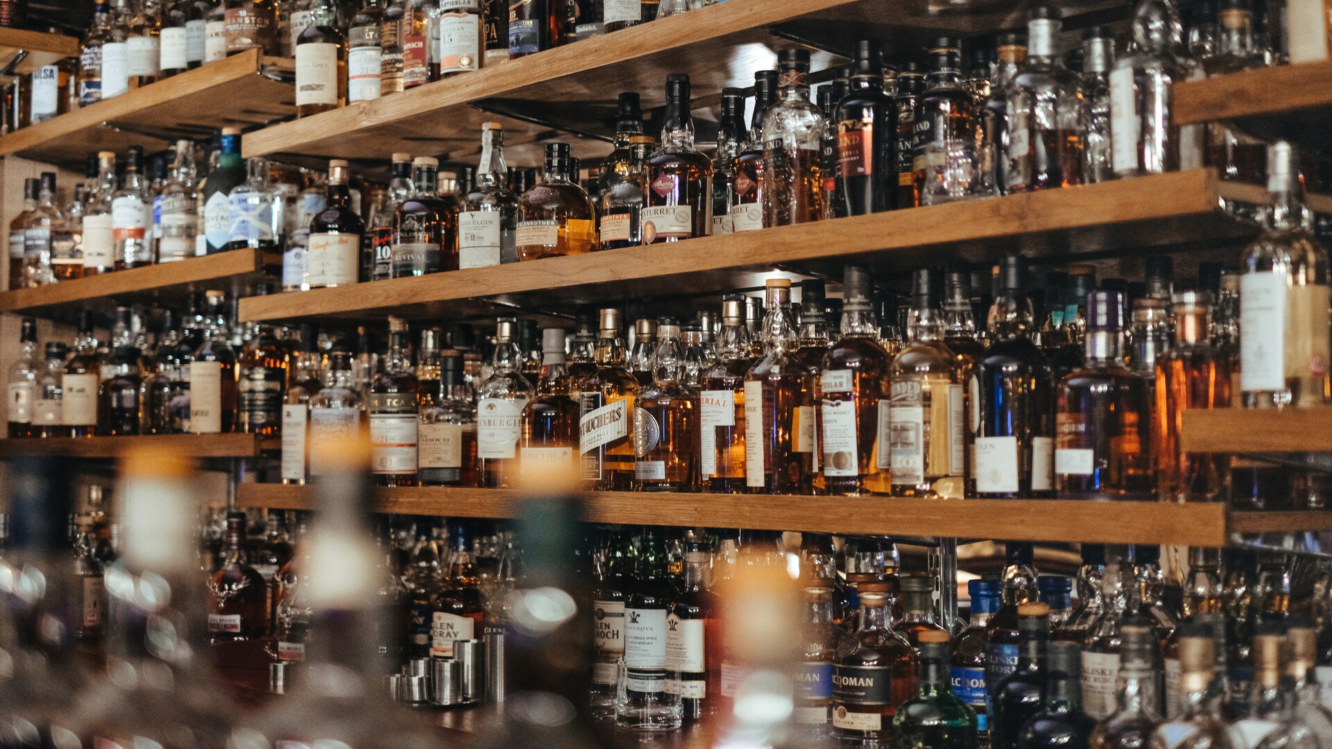 wall of whiskey bottles on wooden shelves