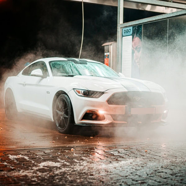 coupé sport blanc dans un tunnel de lavage