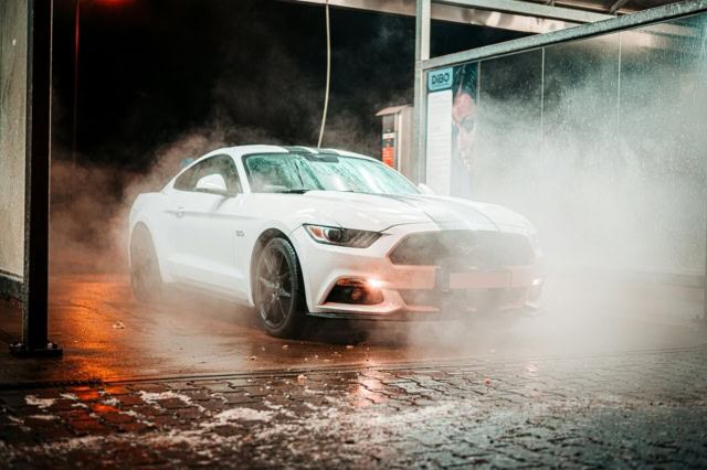 coupé sport blanc dans un tunnel de lavage