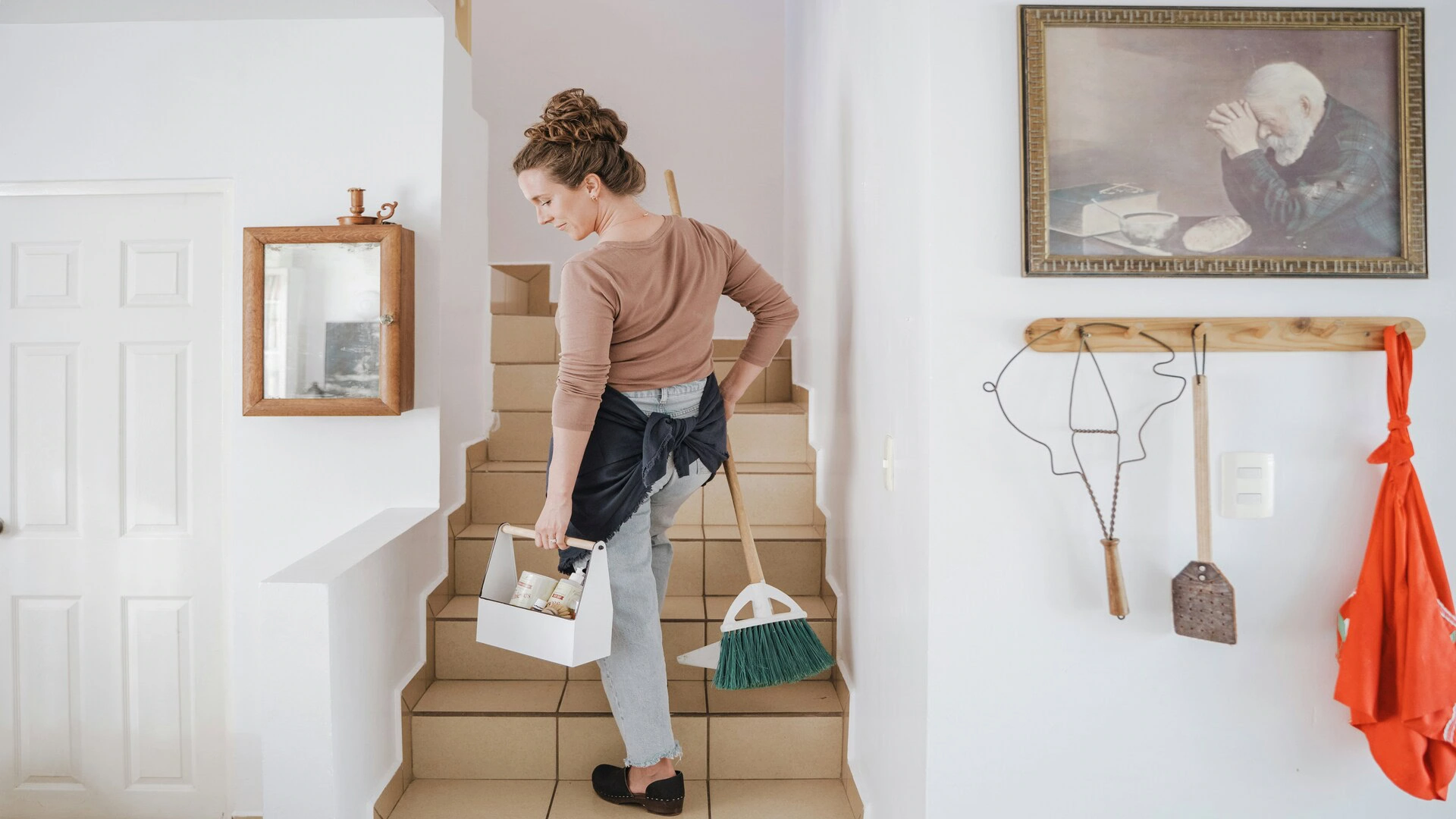 woman cleaning staircase in bright hallway