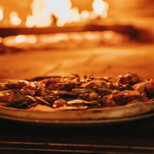 wood fired pizza baking in a glowing oven