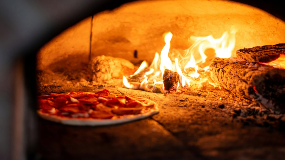 wood fired pizza baking in flames