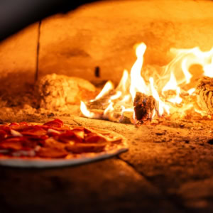 wood fired pizza baking in flames