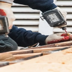 workers using power tools on wood planks
