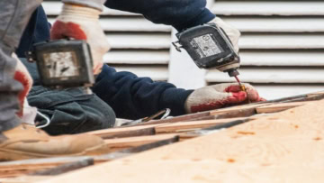 workers using power tools on wood planks