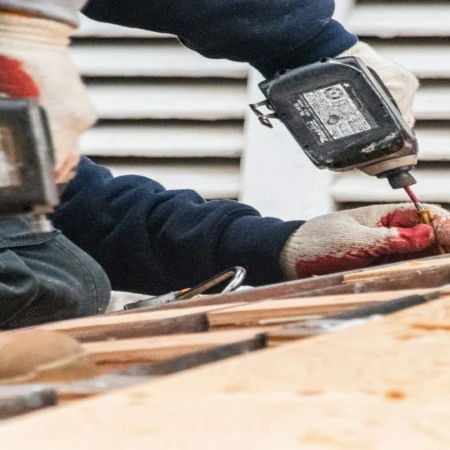 workers using power tools on wood planks