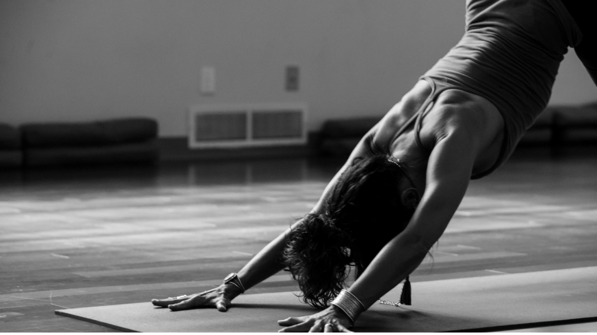 black and white yoga forward fold in studio