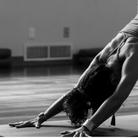 black and white yoga forward fold in studio